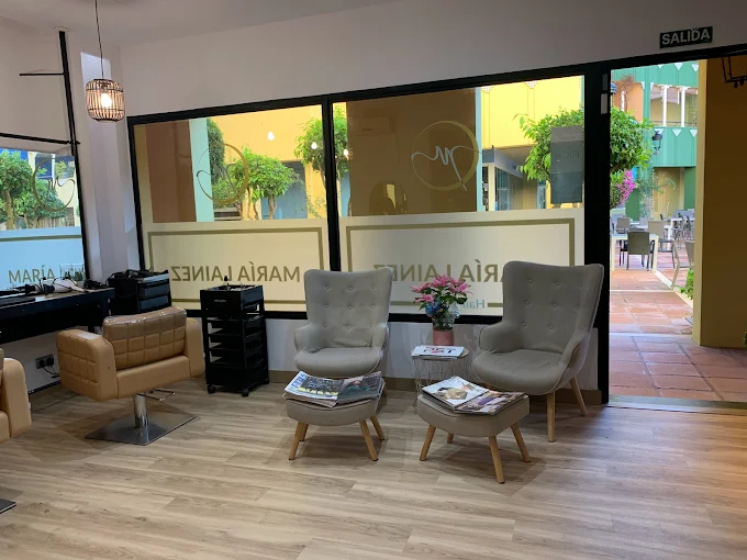 Seating area and entrance inside María Lainez Hair Stylist in Sotogrande Marina
