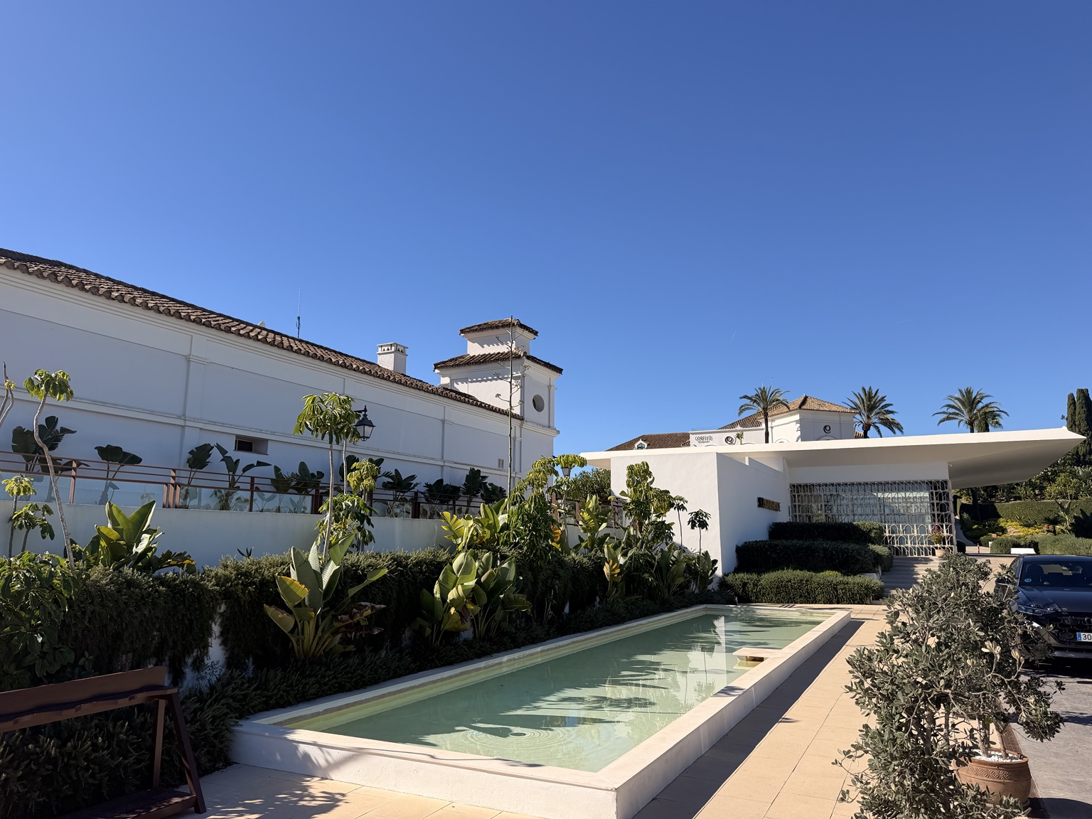 White buildings, landscaped entrance and long water feature at SO/ Sotogrande